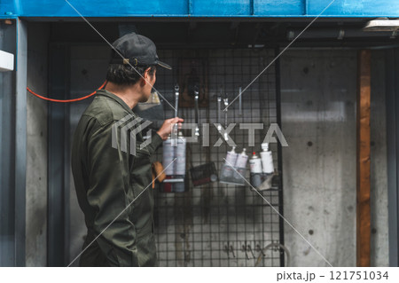 壁掛け工具を整理整頓する自動車整備士・メカニックの男性 壁掛け工具を整理整頓する自動車整備士・メカニックの男性 121751034