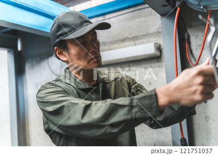 壁掛け工具を整理整頓する自動車整備士・メカニックの男性 壁掛け工具を整理整頓する自動車整備士・メカニックの男性 121751037