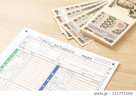 机に置かれた確定申告書類とお金 121751560