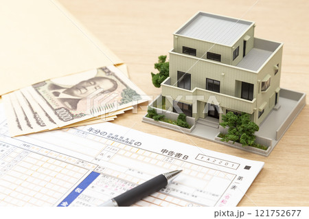 机に置かれた確定申告書類と住宅模型 机に置かれた確定申告書類と住宅模型 121752677