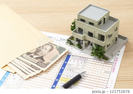 机に置かれた確定申告書類と住宅模型 机に置かれた確定申告書類と住宅模型 121752678