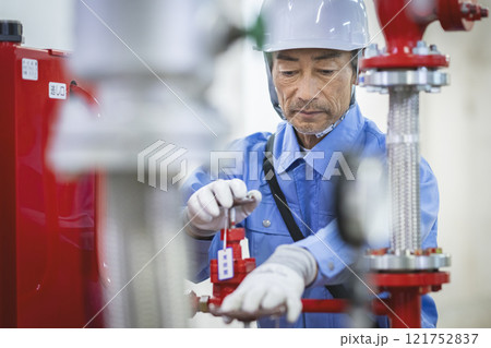 スプリンクラー設備の点検をするベテランの作業員　ビルメンテナンススタッフ　イメージ　 121752837