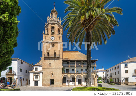Ronda town in Spain. Historic town square with church and palm tree. Sunny day, traditional architecture. Ronda town in Spain. Historic town square with church and palm tree. Sunny day, traditional architecture. 121753908