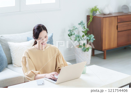 家でパソコンで仕事する女性 121754406