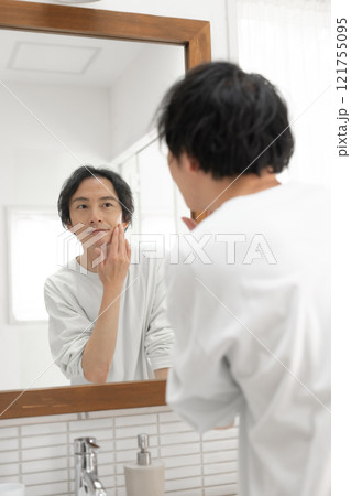 洗面所で鏡を見る男性 121755095