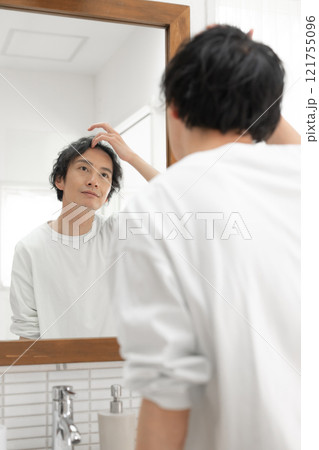 洗面所で鏡を見る男性 121755096