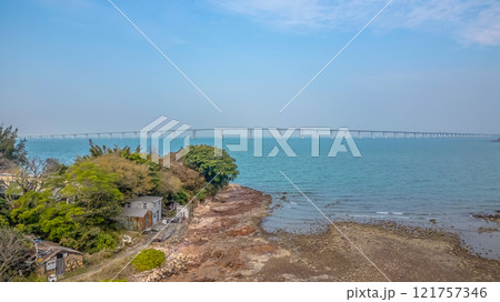 Coastal Landscape with Rustic House and Distant Bridge at HK Dec 31 2024 121757346