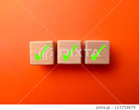 Green tick marking wooden cube for checklist in a row or to do list. Green tick marking wooden cube for checklist in a row or to do list. 121758679