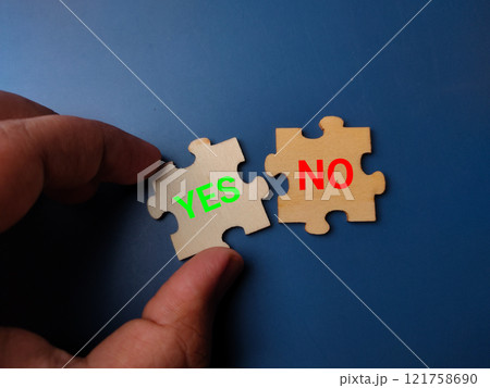 Hand holding wooden puzzle written the word YES OR NO. Yes or No concept. 121758690