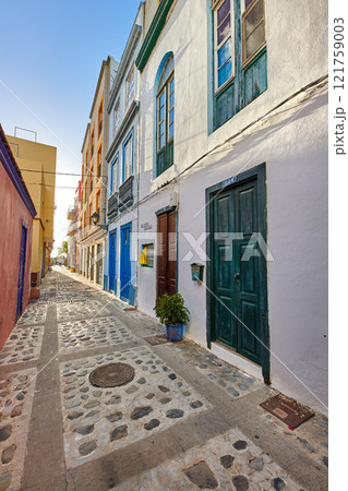 City view of residential houses or buildings in quiet alleyway street in Santa Cruz, La Palma, Spain. Historical spanish and colonial architecture in a tropical village and famous tourism destination City view of residential houses or buildings in quiet alleyway street in Santa Cruz, La Palma, Spain. Historical spanish and colonial architecture in a tropical village and famous tourism destination 121759003