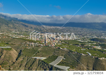 Beautiful landscape of a small agricultural village on a sunny afternoon near a highway or busy road for logistics or transport of goods. Banana plantations in the town of Los Llanos, La Palma, Spain 121759034