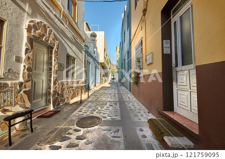 Scenic street view of old historic houses, residential buildings, traditional infrastructure in cobblestone alleyway road. Tourism abroad, overseas travel destination in Santa Cruz de La Palma, Spain 121759095