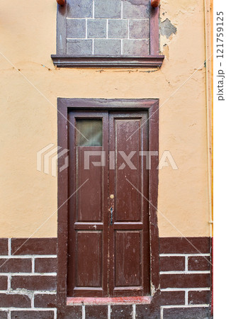 Old house or church with peeling paint on wall or window and wooden shutter door. Vintage and aged residential building built in a traditional architectural style or design in Santa Cruz de La Palma Old house or church with peeling paint on wall or window and wooden shutter door. Vintage and aged residential building built in a traditional architectural style or design in Santa Cruz de La Palma 121759125