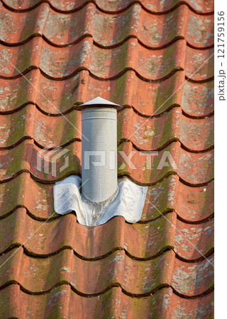 Ventilation pillar and chimney on rooftop of a house or factory building contributing to air pollution. Construction of an exterior chute for air flow with copyspace for cooling and heating control Ventilation pillar and chimney on rooftop of a house or factory building contributing to air pollution. Construction of an exterior chute for air flow with copyspace for cooling and heating control 121759156