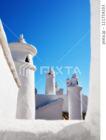Historic ventilation chimney on a roof of a vintage building. Traditional architecture airing system in a village. Exterior view of a rural home or house rooftop isolated on a blue sky background Historic ventilation chimney on a roof of a vintage building. Traditional architecture airing system in a village. Exterior view of a rural home or house rooftop isolated on a blue sky background 121759203