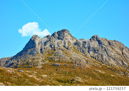 Landscape view of mountains, blue sky with clouds and copy space in Norway. Hiking, discovering scenic countryside and rough terrain. Sun shining on vast background of nature expanse and hiking trail 121759257