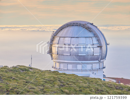 Closeup of an astronomical observatory with clear sky and copy space. Telescope surrounded by greenery and located on an island at the edge of a cliff. Roque de los Muchachos Observatory in La Palma Closeup of an astronomical observatory with clear sky and copy space. Telescope surrounded by greenery and located on an island at the edge of a cliff. Roque de los Muchachos Observatory in La Palma 121759399