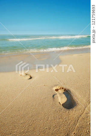 Footsteps on a sand beach seaside with a white foamy wave from the blue sea. Soft waves of clear water. Sandy beach with human footprints. Pleasing blue sky over a peaceful sea. Sandy tropical ocean. Footsteps on a sand beach seaside with a white foamy wave from the blue sea. Soft waves of clear water. Sandy beach with human footprints. Pleasing blue sky over a peaceful sea. Sandy tropical ocean. 121759693