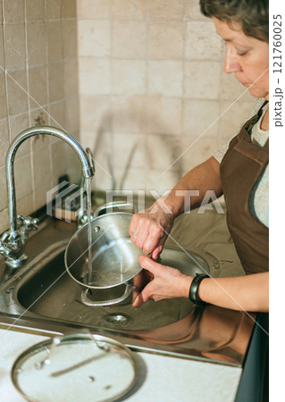 senior woman washing dishes senior woman washing dishes 121760025