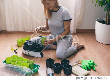 woman plant seedlings at home 121760045