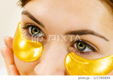 Woman with gold patches under eyes 121760894
