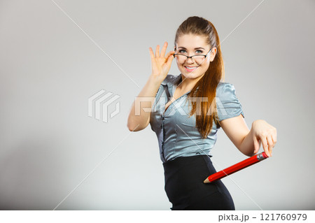 Teacher looking elegant woman holding big pencil Teacher looking elegant woman holding big pencil 121760979
