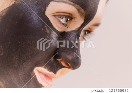 Woman with charcoal facial mask 121760982