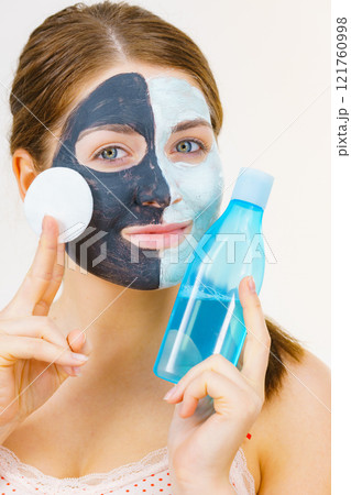 Girl remove black white mud mask from face Girl remove black white mud mask from face 121760998