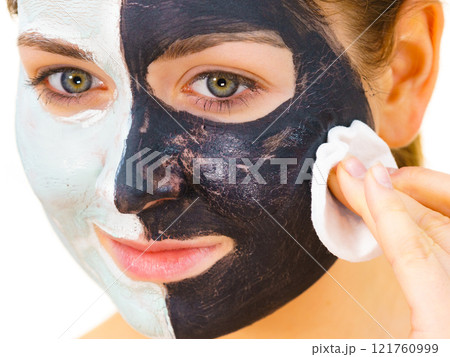 Girl remove black white mud mask from face 121760999