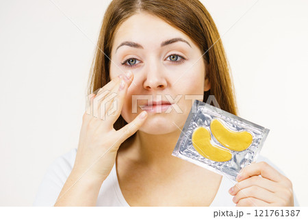 Woman ready to apply gold eye patches 121761387