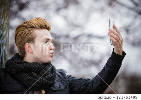 guy taking self picture with phone outdoors 121761499