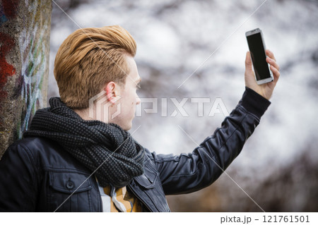 guy taking self picture with phone outdoors guy taking self picture with phone outdoors 121761501