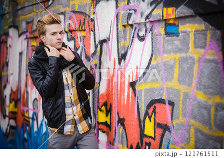Fashion male portrait on graffiti wall 121761511