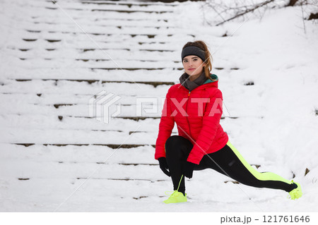Woman exercising legs outside during winter Woman exercising legs outside during winter 121761646