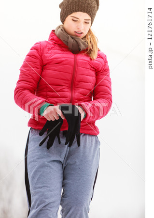 Woman wearing sportswear exercising outside during winter 121761714