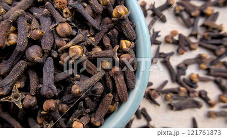 Aromatic Cloves in a Light Blue Bowl with Blurred Background, Close-Up Shot 121761873