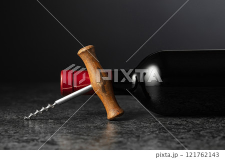 Corkscrew and bottle of red wine. 121762143