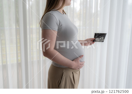 Gen Z pregnant woman holding ultrasound scan photo of a fetus. Concept of pregnancy, Maternity prenatal care Gen Z pregnant woman holding ultrasound scan photo of a fetus. Concept of pregnancy, Maternity prenatal care 121762500