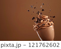 Side view of mocha or chocolate mousse dessert with smooth texture with crushed chocolate pieces in motion, soft brown background. Color trend concept, color of the year 2025. Banner with copy space. 121762602