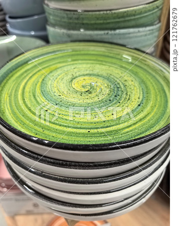 Beautifully crafted spiral ceramic dish showcases vibrant green hues 121762679