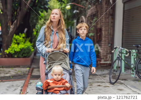 Mother with her two sons exploring lush streets of Condesa, Mexico City. Family adventure in a vibrant urban oasis. Travel, family bonding, and urban greenery concept in Latin America 121762721