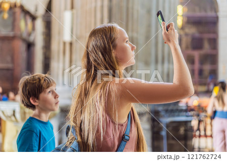 A woman and her son tourists exploring the Metropolitan Cathedral in Mexico City. Woman admiring the architecture and history of Mexico's iconic landmark. Concept of cultural heritage, religious 121762724