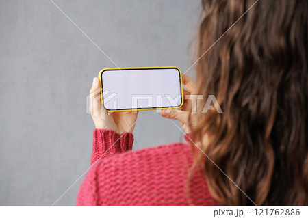 close-up image of woman in pink sitting indoors and using her smartphone. mock-up close-up image of woman in pink sitting indoors and using her smartphone. mock-up 121762886