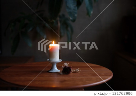 燭台に乗せて火を灯したキャンドル 121762996