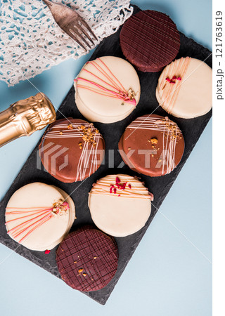 Ischler cookies coated with brown an white chocolate glaze on black Ischler cookies coated with brown an white chocolate glaze on black 121763619