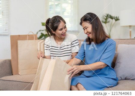 Mother and Child Enjoy Online Shopping Together Using a Credit Card in a Cozy Home Environment 121764063