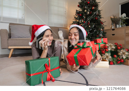 Happy Lesbian Couple Celebrating Christmas Together with Gifts and Joyful Smiles in a Festive Holiday Home Setting Happy Lesbian Couple Celebrating Christmas Together with Gifts and Joyful Smiles in a Festive Holiday Home Setting 121764086