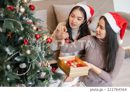 Joyful Young Couple Celebrating Christmas Together with Festive Decorations and Cheerful Atmosphere 121764564