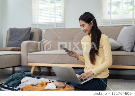 Cheerful Young Woman Packing Suitcase and Preparing Passport for Travel Adventure at Home Cheerful Young Woman Packing Suitcase and Preparing Passport for Travel Adventure at Home 121764609