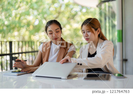Confident Businesswoman Providing Guidance to New Employee in Modern Office Setting Confident Businesswoman Providing Guidance to New Employee in Modern Office Setting 121764763